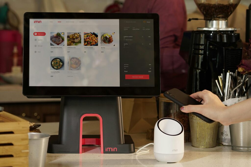 A modern point of sale system with contactless payment capability in a cafe setting.