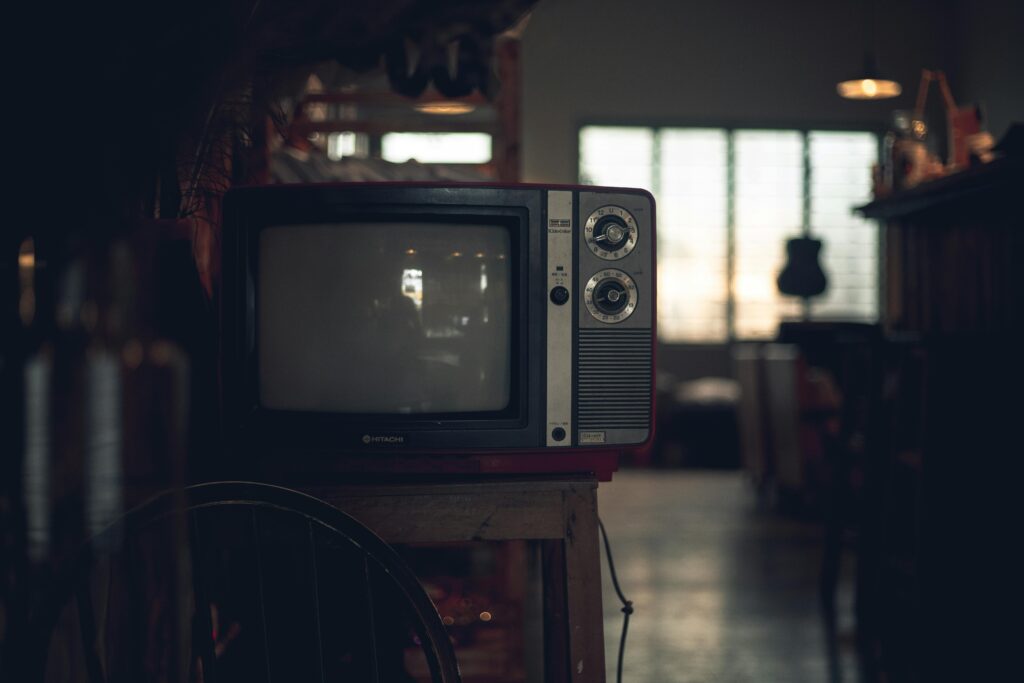 A classic CRT television in a dimly lit vintage room in Ho Chi Minh City, Vietnam.