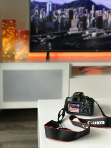 Stylish living room featuring a DSLR camera and cityscape on TV screen.